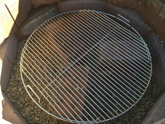 To keep the flames away from the cement, he filled the pit with gravel, some bricks, and a grill cover.