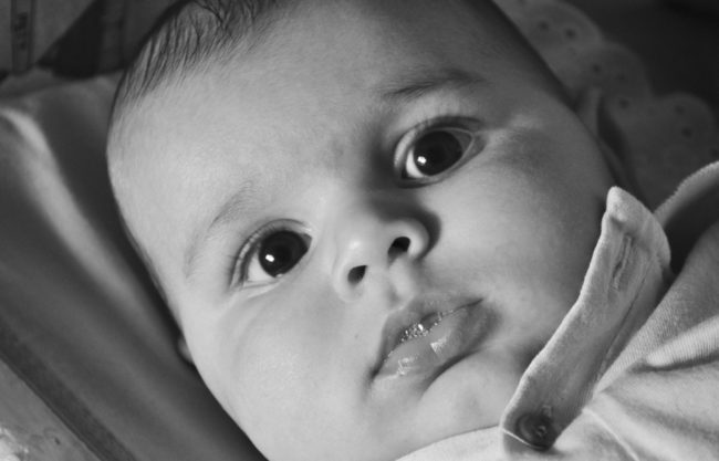 Newborns can only see in black and white for the first few months of their lives. This is because their <a href="http://www.bausch.com/vision-and-age/infant-eyes/eye-development#.Vvw--IwrJz-" target="_blank">vision isn't fully developed yet</a>. They also can only see about a foot in front of their face. The first color they are able to distinguish besides black, white, or gray is red.