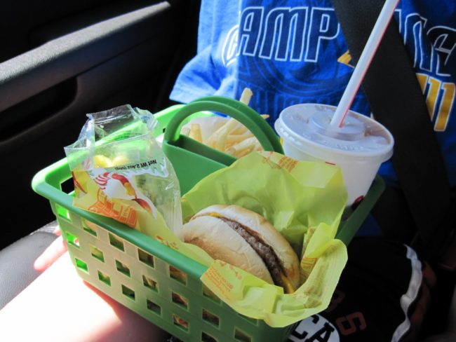 Keep kids from making a mess while they eat in the car by bringing along shower totes.