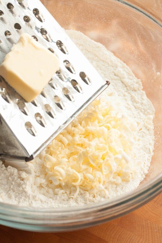 Making great pie crust is all about keeping the chunks of butter cold, so freeze butter beforehand. Grate it into the mixture for finer pieces that'll help you get your hands out of there sooner.