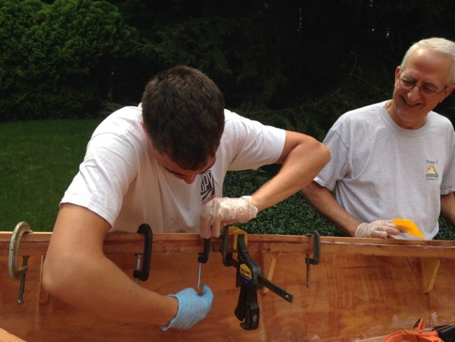 While he was in college, work was slow on the boat. Here BenderRodriguezz and his dad are clamping and gluing African mahogany strips around the hull.