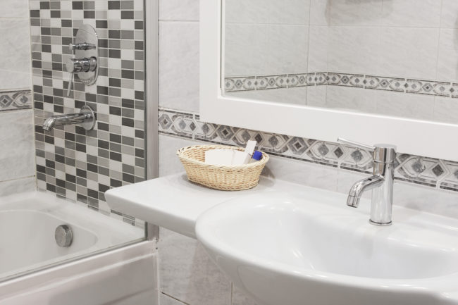Add interest to your bathroom by mixing tiles. You could use small subway tiles for your backsplash and larger ones on the tub!