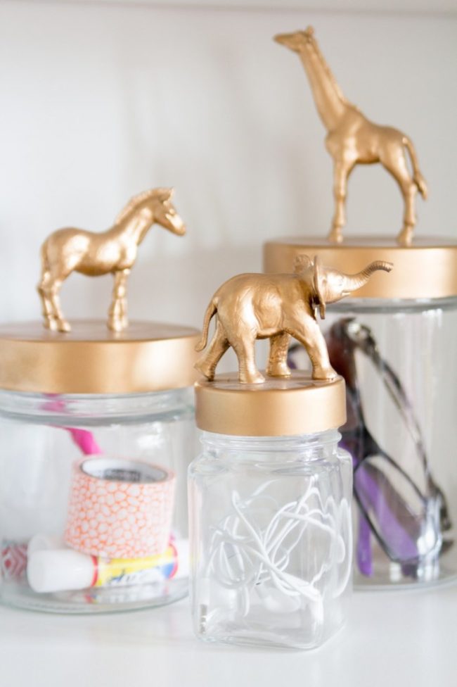 Pick up some little toys from the dollar store, glue them to jar lids, and <a href="http://sayehpezeshki.com/amanda-risiuss-bright-diy-home-office-studio-space/" target="_blank">paint them</a> to give your desk storage a facelift.
