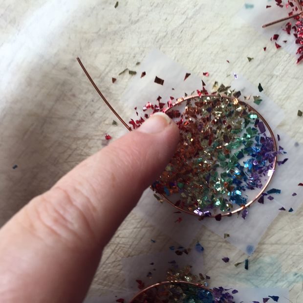 Press the glitter into the tape...don't worry, it will come off cleanly.