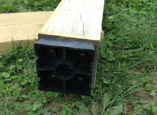 By adding plastic standoffs to the bottom of each post, he ensured that the wood would not come into direct contact with concrete. That'd prevent it from rotting.