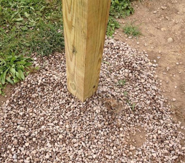 Instead of refilling the holes with soil, he used small stones to help with drainage. The more moisture you can keep away from wooden beams, the better.