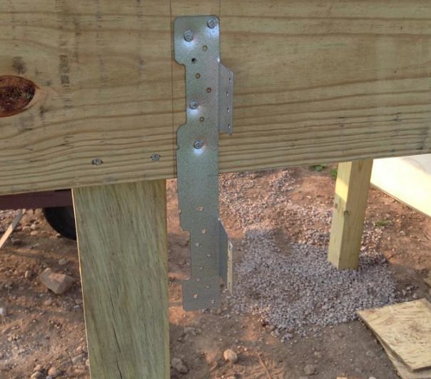 Once the frame was in place, he determined where the steps for the deck would go before mounting some stair stringer brackets.