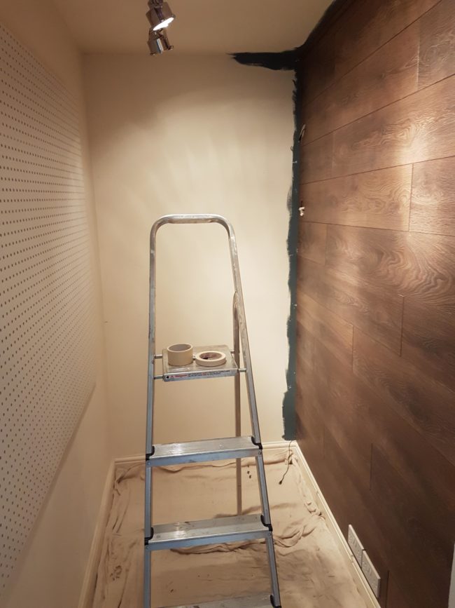 He began painting the adjacent wall before finishing the laminate to make the paint process easier later on.