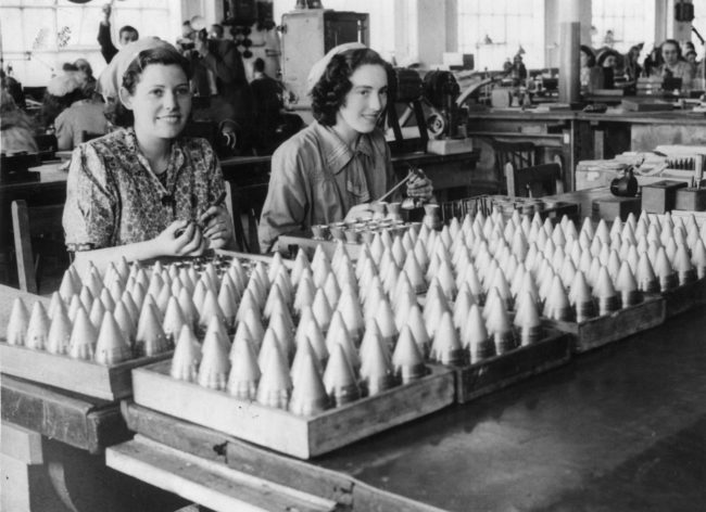 A smile goes the extra mile for these factory workers in 1941. 