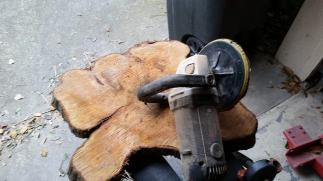 Using an electric sander and sandpaper, he smoothed the surfaces out.