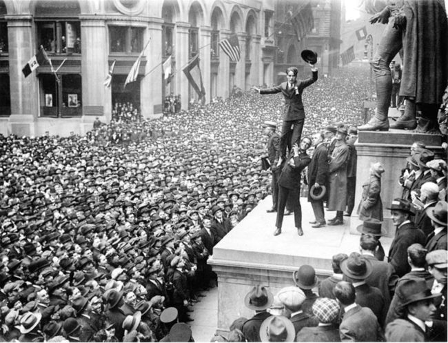 To promote liberty bonds, Douglas Fairbanks Jr. holds up Charlie Chaplin on Wall Street in 1918.