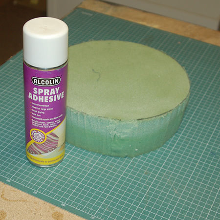 Secure the fabric to the foam by applying spray adhesive to both the foam and the underside of the fabric. 