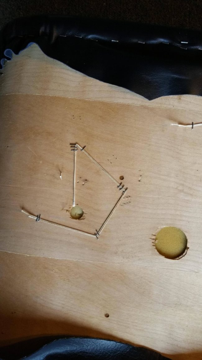 He learned that for this type of chair, the buttons had to be attached first, then he could staple the edges.