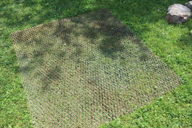 Cut your grate to the size of the pit and affix it by adding another layer of rocks to the top.