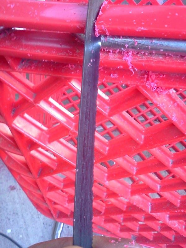 The first step is to get rid of the wheels. This happens by sawing through the places where the plastic attaches to the metal frame on the bottom of the cart. 