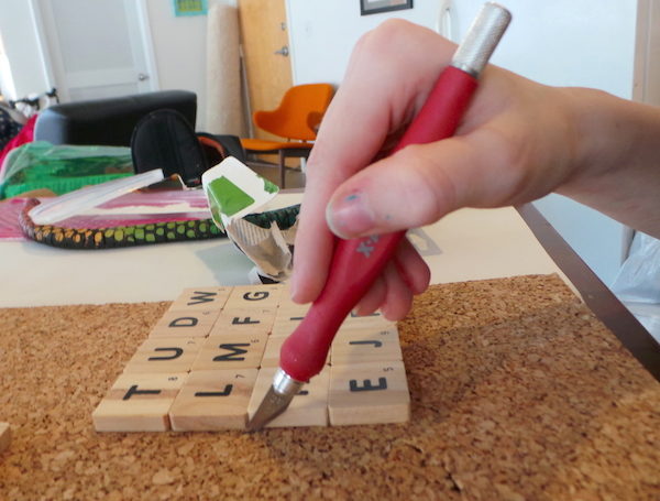 After letting the glue dry, she cut around the tiles with the X-Acto knife.