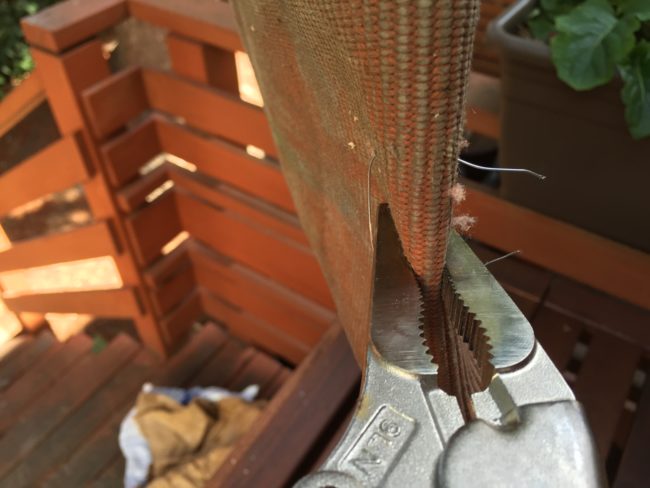 To keep the herbs and soil from falling out, he cut and threaded short lengths of bailing wire through the holes and twisted the ends to lock them in place.