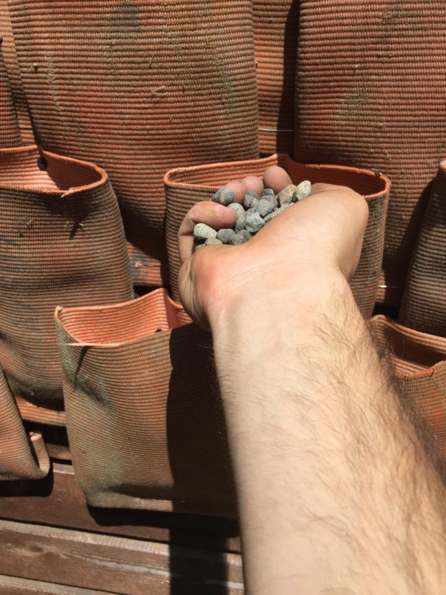 Before planting, he added a handful of gravel to the  pockets for easy drainage. 