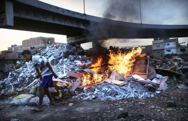 Burning garbage just off a major highway that cuts through Rio.