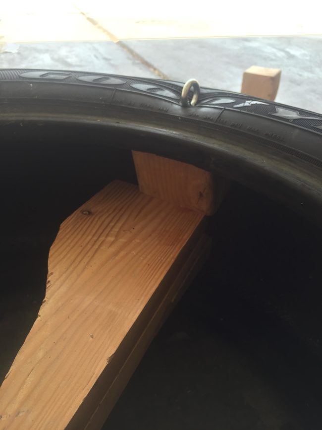 Then, using a couple of planks for support, he attached the swing's hooks to four small blocks of wood inside the tire.