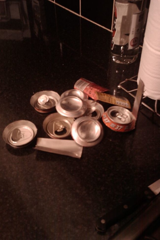 He carefully cut the tops and bottoms off of the cans.