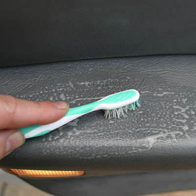 A soft-bristled toothbrush can help you scrub out dirt caught in the leather grain.