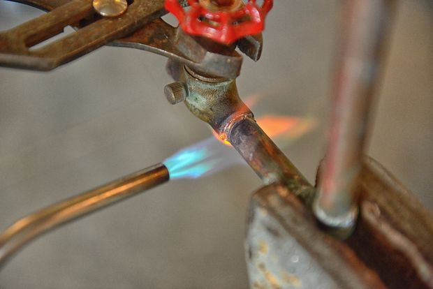 He used a soldering torch to loosen connected portions, then he detached them with a clamp.