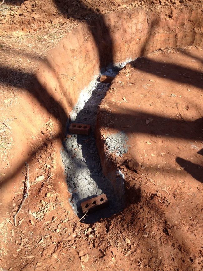 He then added gravel to the hole and bricks to serve as supports for the wall base.