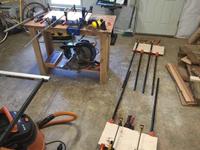 After cutting his wood planks to size, he glued and clamped them together.