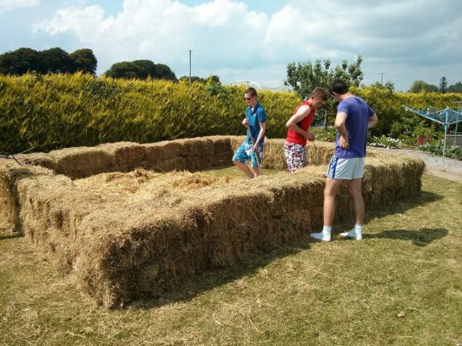 They began stacking bales of hay in the shape of their pool. 