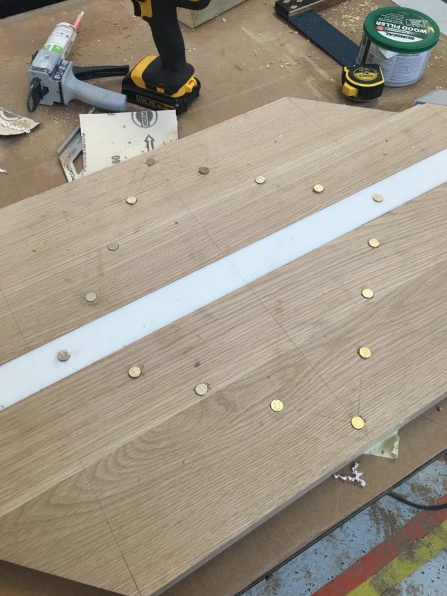 He cut the brass pieces to size, hammered them into place, and sanded them down flush with the table.