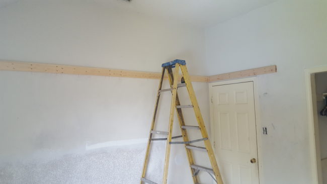 The builder got started right away by screwing wood beams to the walls.