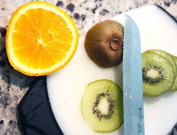 Because it's impractical to carry around a whole orange on your ear, our crafter begins by slicing her fruit with a serrated knife.