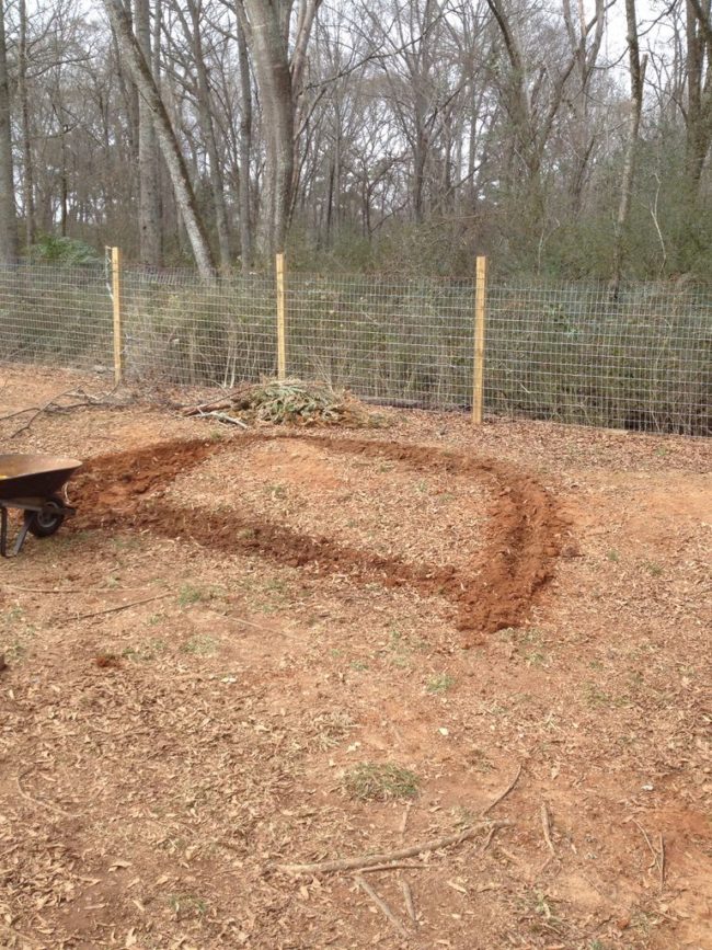 He began by digging out the desired shape for the fire pit.