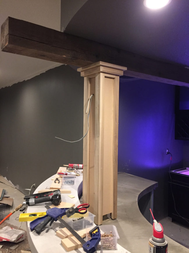Next, the builder glued planks to the columns and attached a wire for the pub light.
