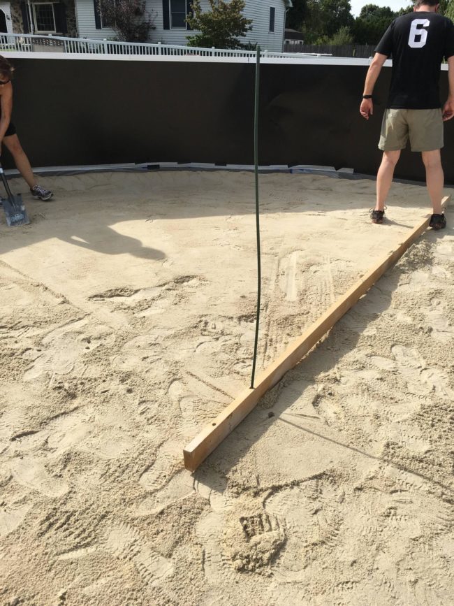 A pool cove is a gentle slope of sand around the edges. A plastic liner goes under it and then the sand in the middle must be evened out, which you can see below.