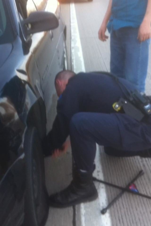 This officer helped a guy change his tire on a freeway.