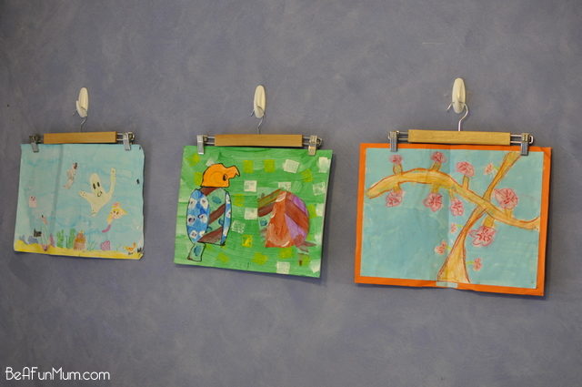 Rotate your kids' drawings by clipping them to clothes hangers and hanging them with Command hooks. No nails necessary!