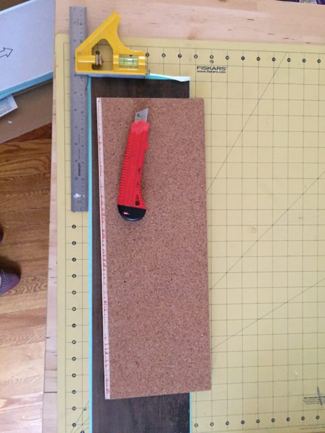 Next, she bought inexpensive flooring and used a piece of plywood to help her cut the planks evenly.
