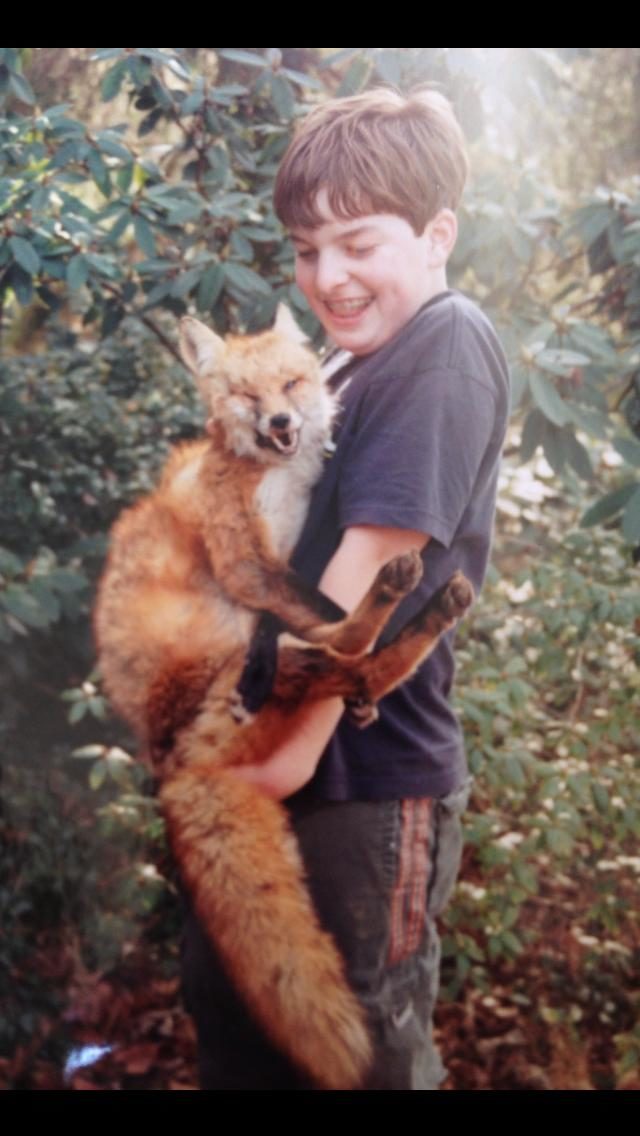 This kid is having the time of his life playing with a dead fox.