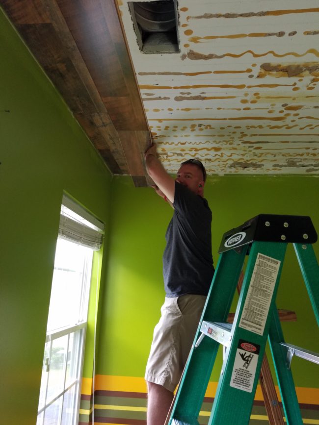 It became the perfect time to try again, so they bought some laminate floor tiles and began gluing and nailing them to the ceiling.