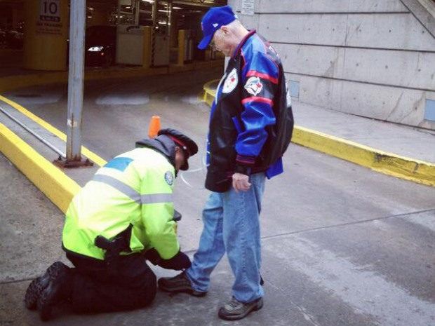 An officer tied a sick old man's shoelaces for him.