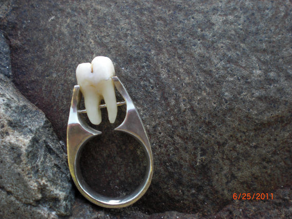 Propose to your partner in style with this delightfully freaky <a href="https://www.etsy.com/listing/76836242/real-human-tooth-tension-set-and-riveted?ga_order=most_relevant&amp;ga_search_type=all&amp;ga_view_type=gallery&amp;ga_search_query=real%20human%20teeth&amp;ref=sr_gallery_11" target="_blank">human tooth ring</a>.