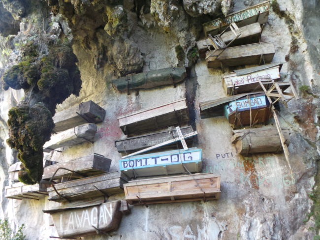 Instead of tombstones, the names of the dead are painted on the exposed side of the coffin. 